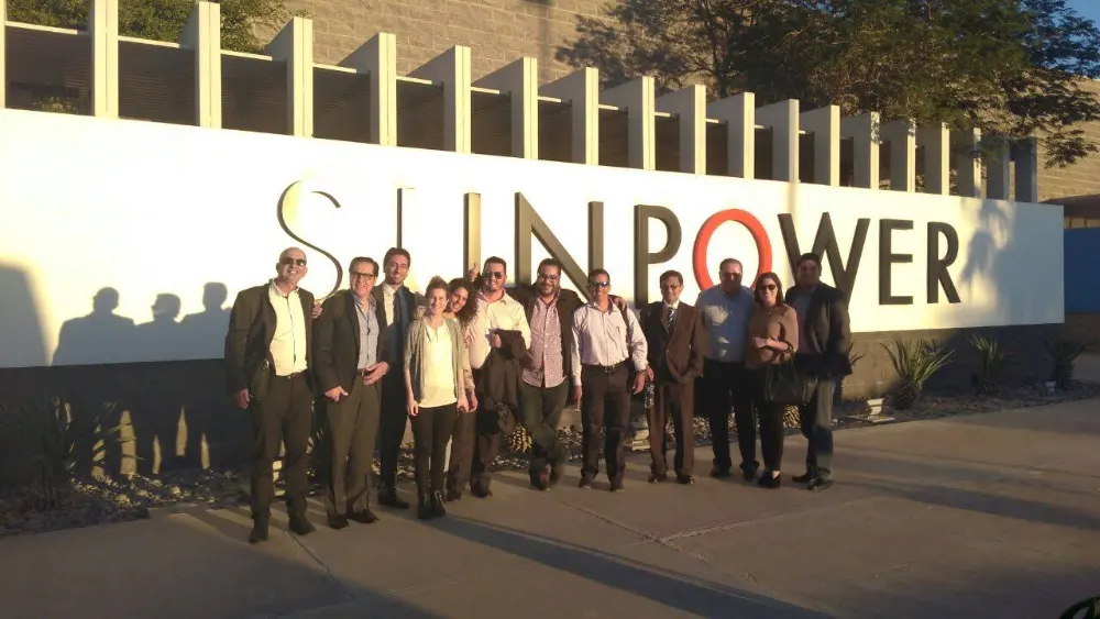 Delegation members in front of the SunPower plant sign in northern Mexico.